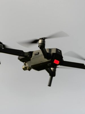 A sleek black quadcopter drone captured in mid-flight, demonstrating modern technology.