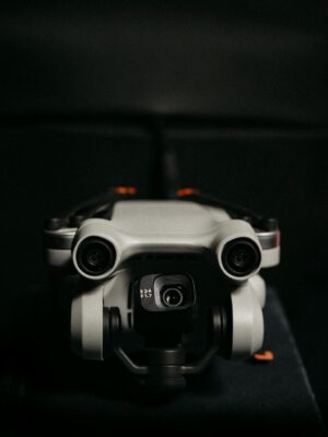 Close-up of a drone camera lens in focus against a dark background, emphasizing technology.
