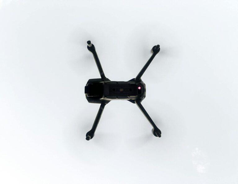 Overhead view of a drone flying in a clear sky, showcasing modern technology.